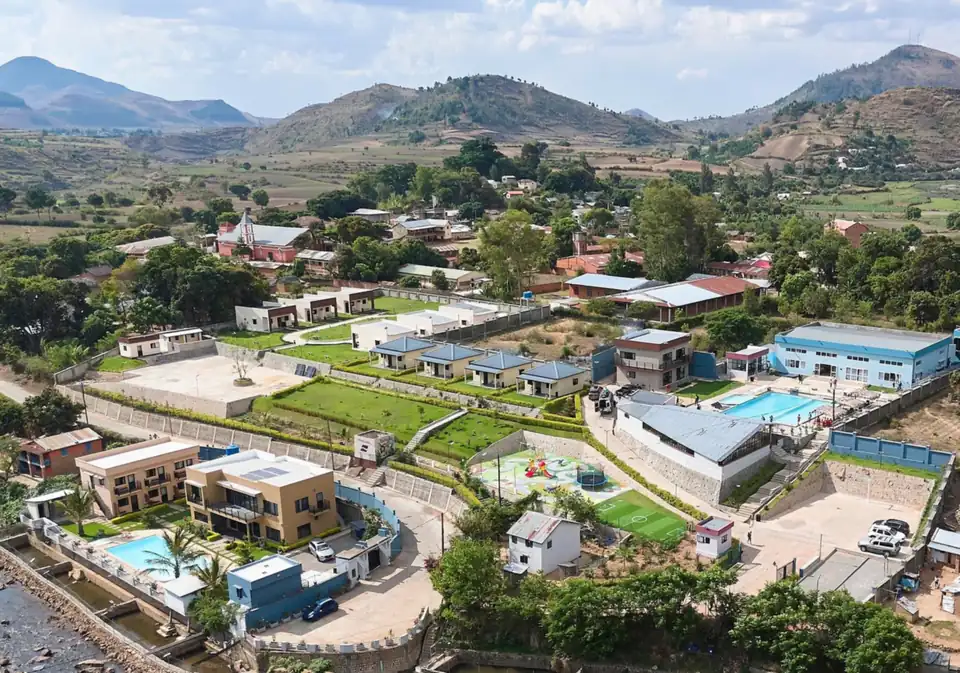 Vue aérienne du Riarano Hotel à Ampefy : bungalows, jardins en terrasses, piscines et rivière, au pied des collines de l'Itasy