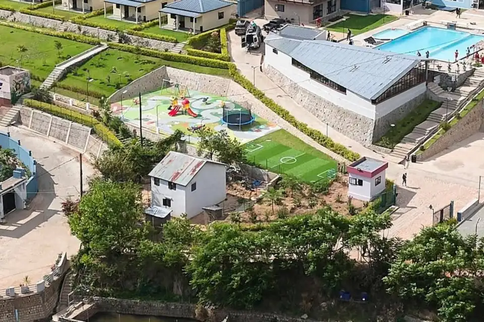Aire de jeux pour enfants avec toboggan et trampoline, à côté du terrain de mini-foot